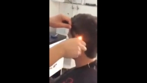 Illustration : "Ce coiffeur coupe les cheveux de son client à l'aide d'un peigne et d'un... briquet"