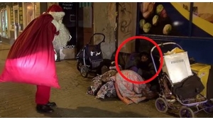 Illustration : "Le Père-Noël s'approche d'un homme qui dort dans la rue. Il ouvre son sac et la suite est magique !"